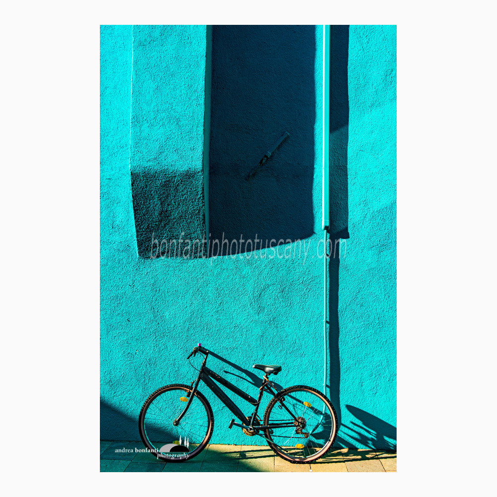 una bici su muro turchese in luce radente.jpg una bici su muro turchese in luce radente.jpg