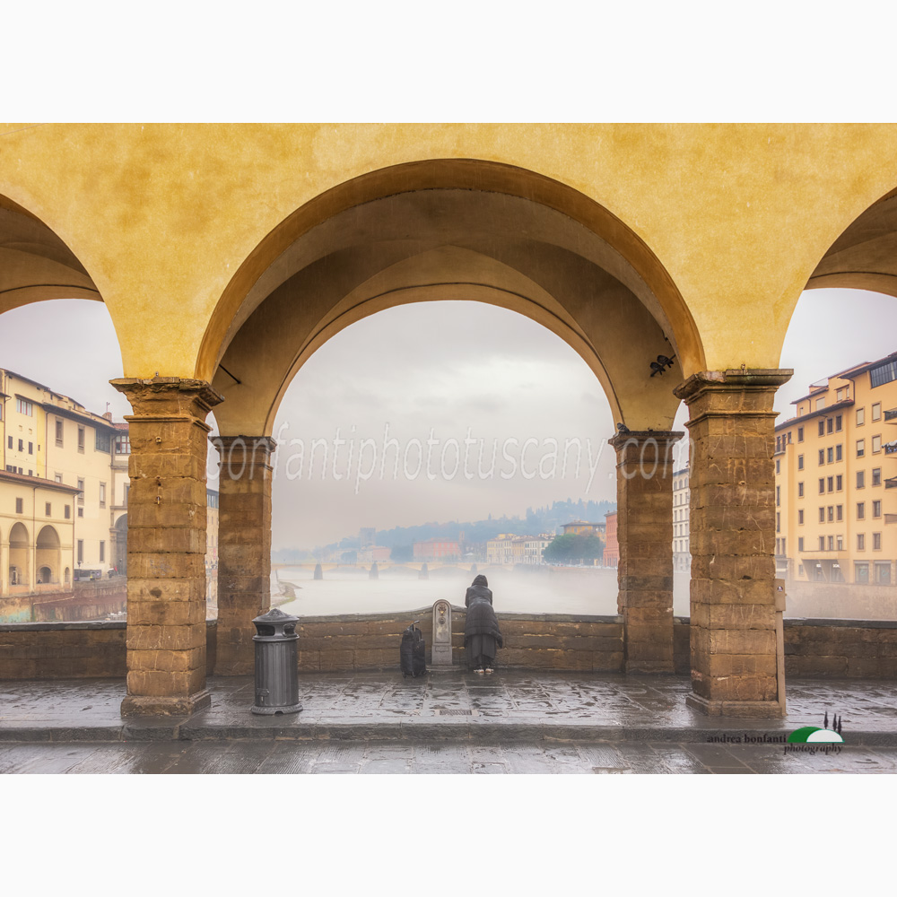 a lonely tourist on the ponte vecchio in a rainy day.jpg