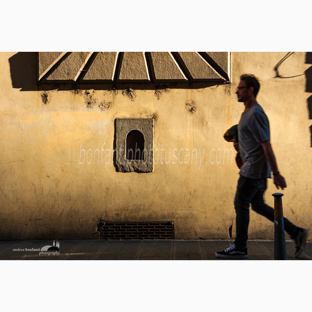 a wine window in via dei serragli with a person walking.jpg
