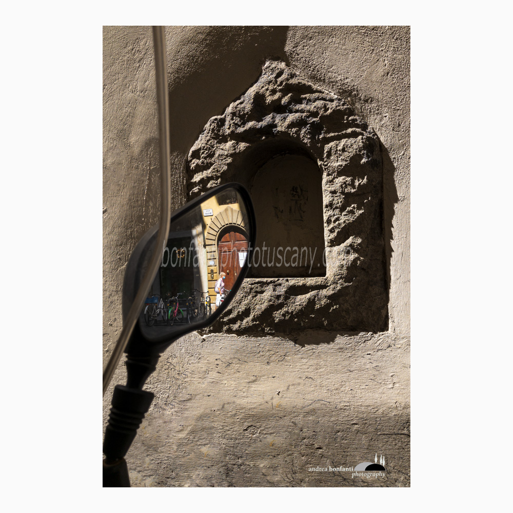 a wine window in via dei velluti with a person walking.jpg