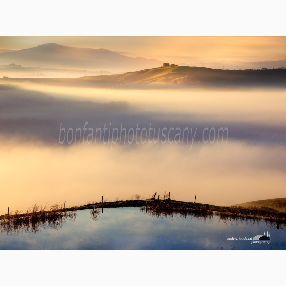 a blue lake and a farmhouse beyond the fog.jpg