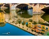 a canoeist rows under the ponte vecchio in florence